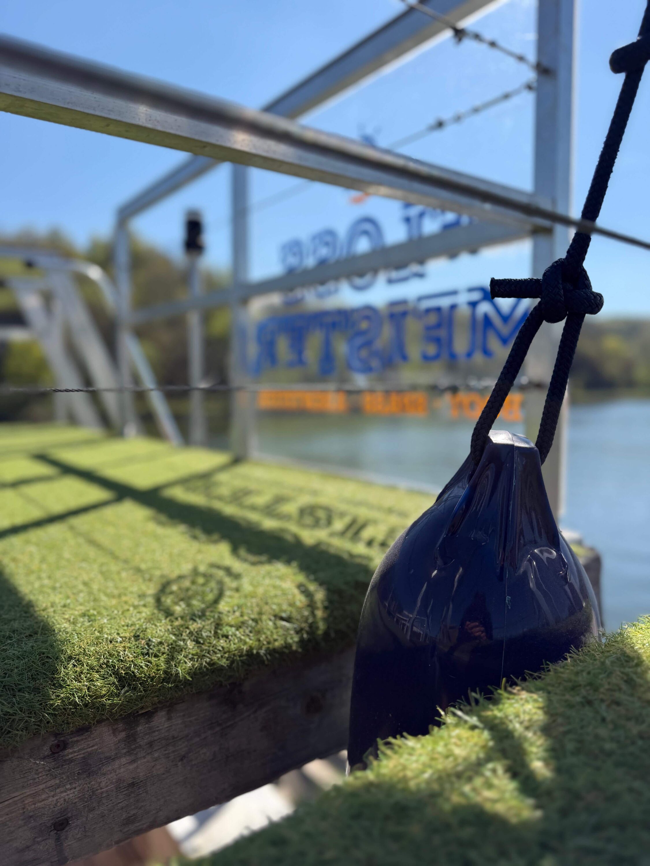 Fender am FLOSSMEISTER-Floss an der Anlegestelle auf der Donau, im Hintergrund das Firmenlogo