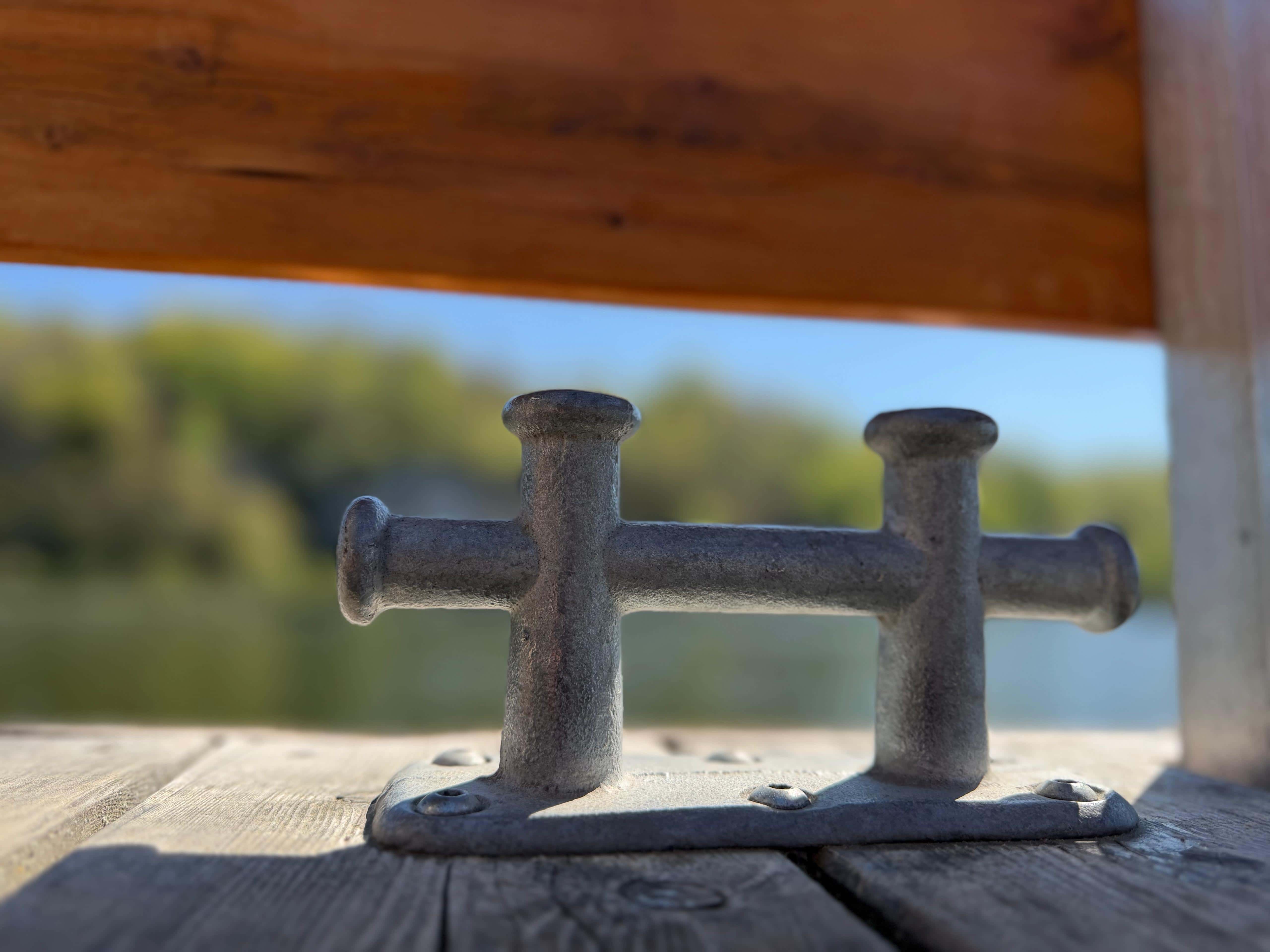 Detailaufnahme einer Klampe auf dem Holzdeck des FLOSSMEISTER-Flosses, im Hintergrund die Donau
